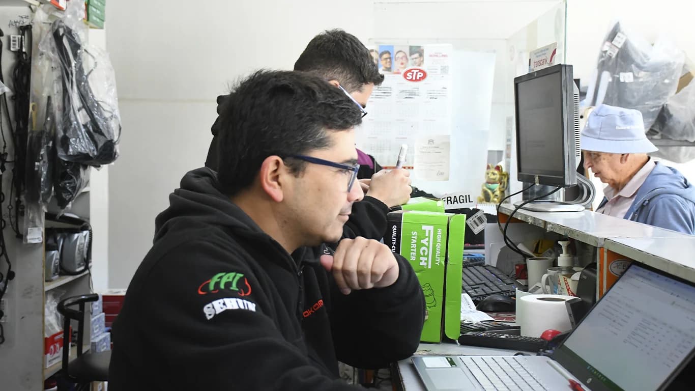 Vendedores de Repuestos Automotrices JFNN atendiendo en el mostrador del local de Melipilla