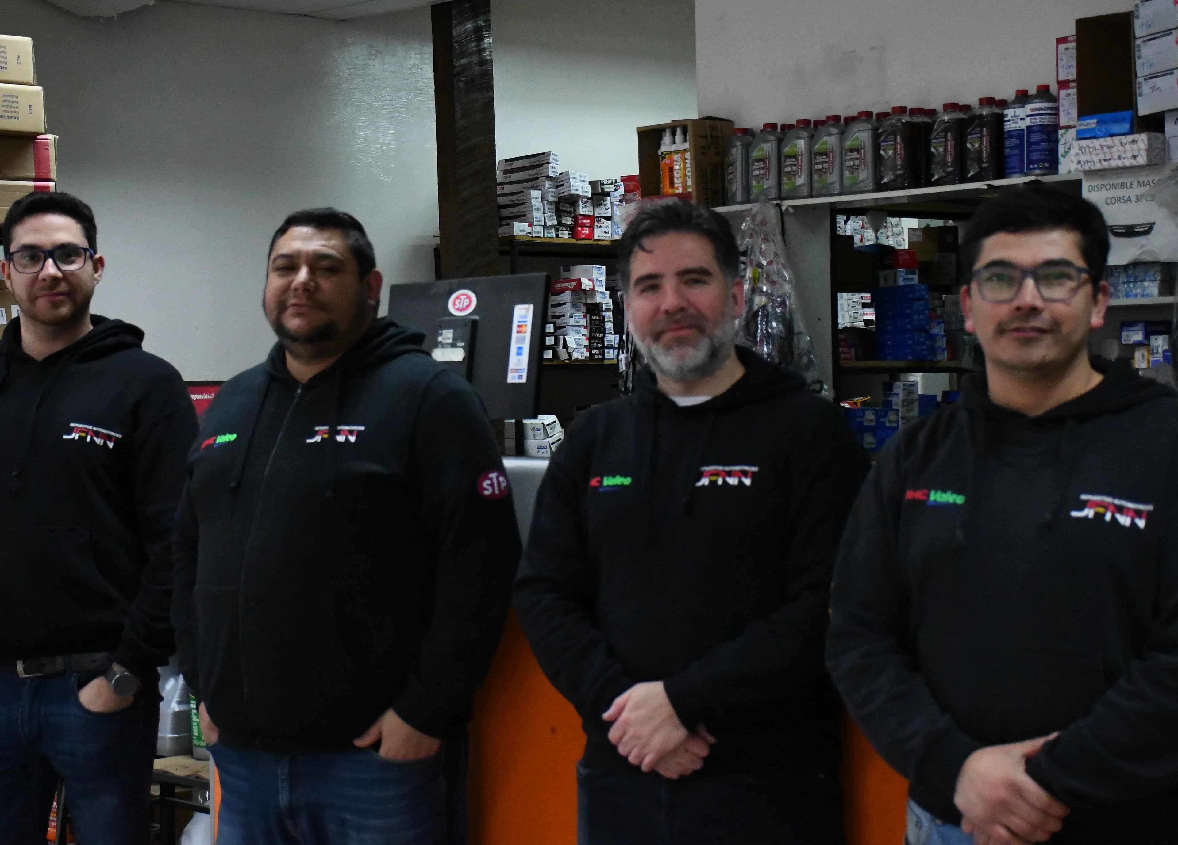 Los cuatro integrantes del equipo de Repuestos Automotrices JFNN en el mostrador del local de Melipilla